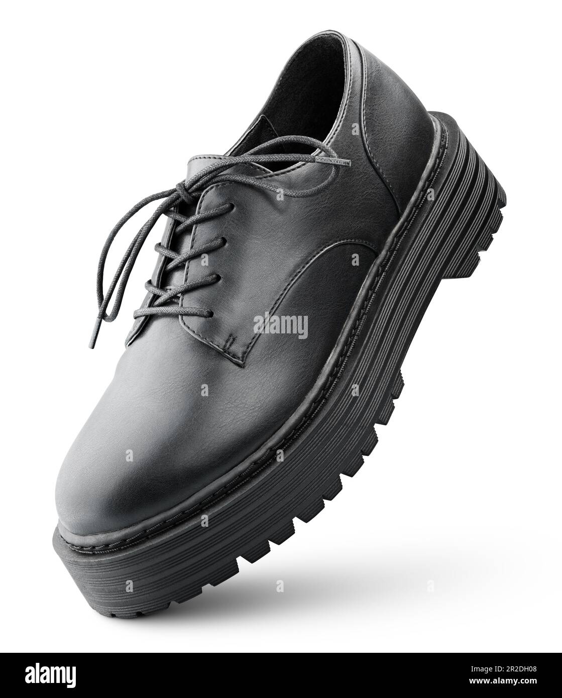 Levitating black leather boot with shoelaces bow stands on the tip. Low