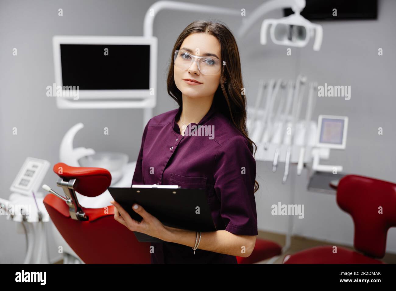 Doctor dentist working in office, using clipboard and making notes. Stock Photo