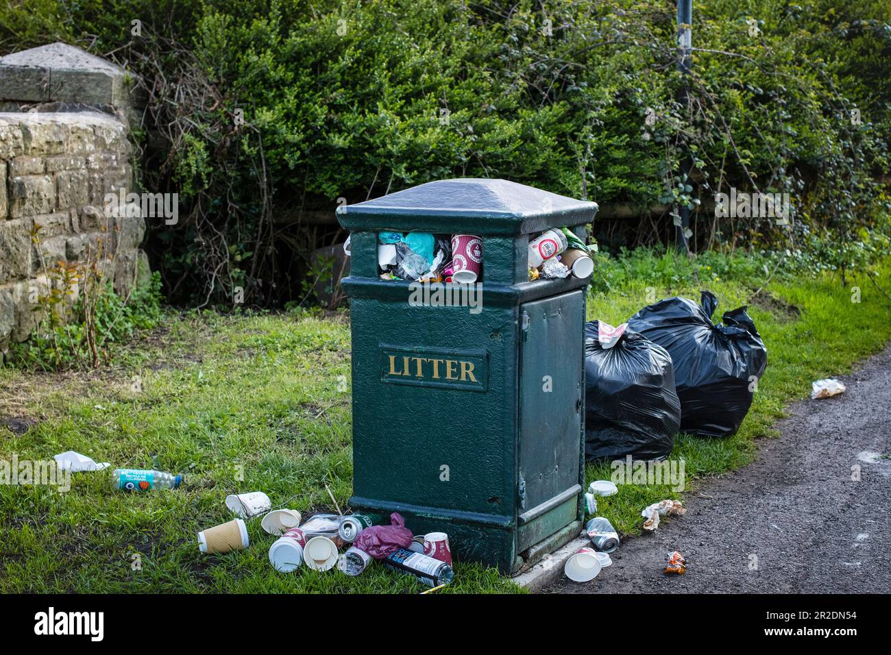 Lots of dumped rubbish, trash, around a rubbish bin, trash bin after day trippers, Stock Photo
