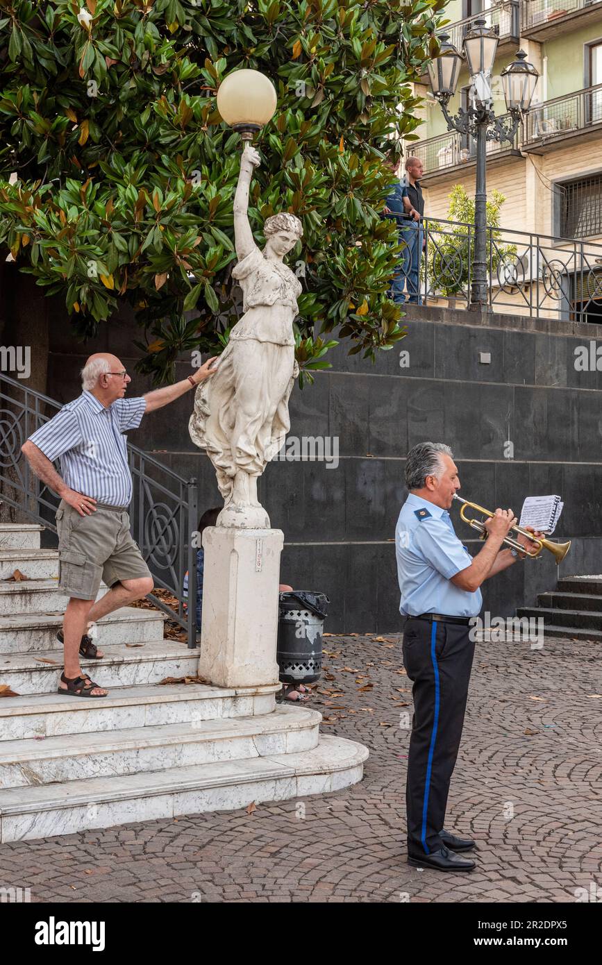 A member of the town band plays the trumpet in the central piazza of the Sicilian town of Zafferana Etnea, high on the slopes of Mount Etna Stock Photo