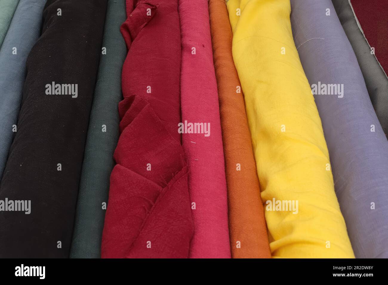 Samples of cloth and fabrics in different colors found at a fabrics market. Stock Photo