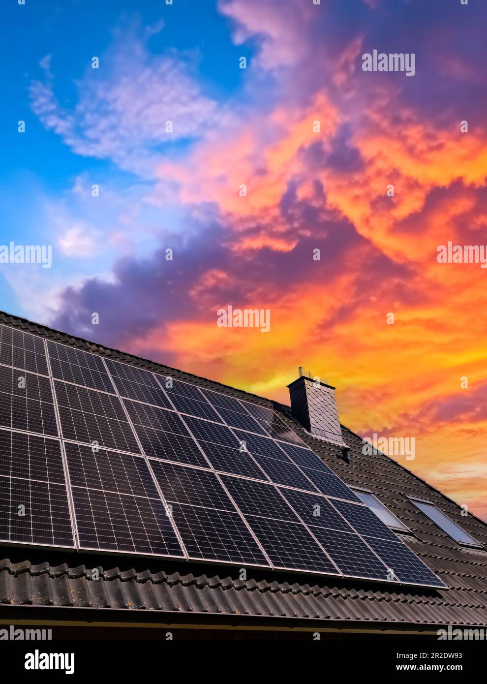 Solar panels producing clean energy on a roof of a residential house Stock Photo