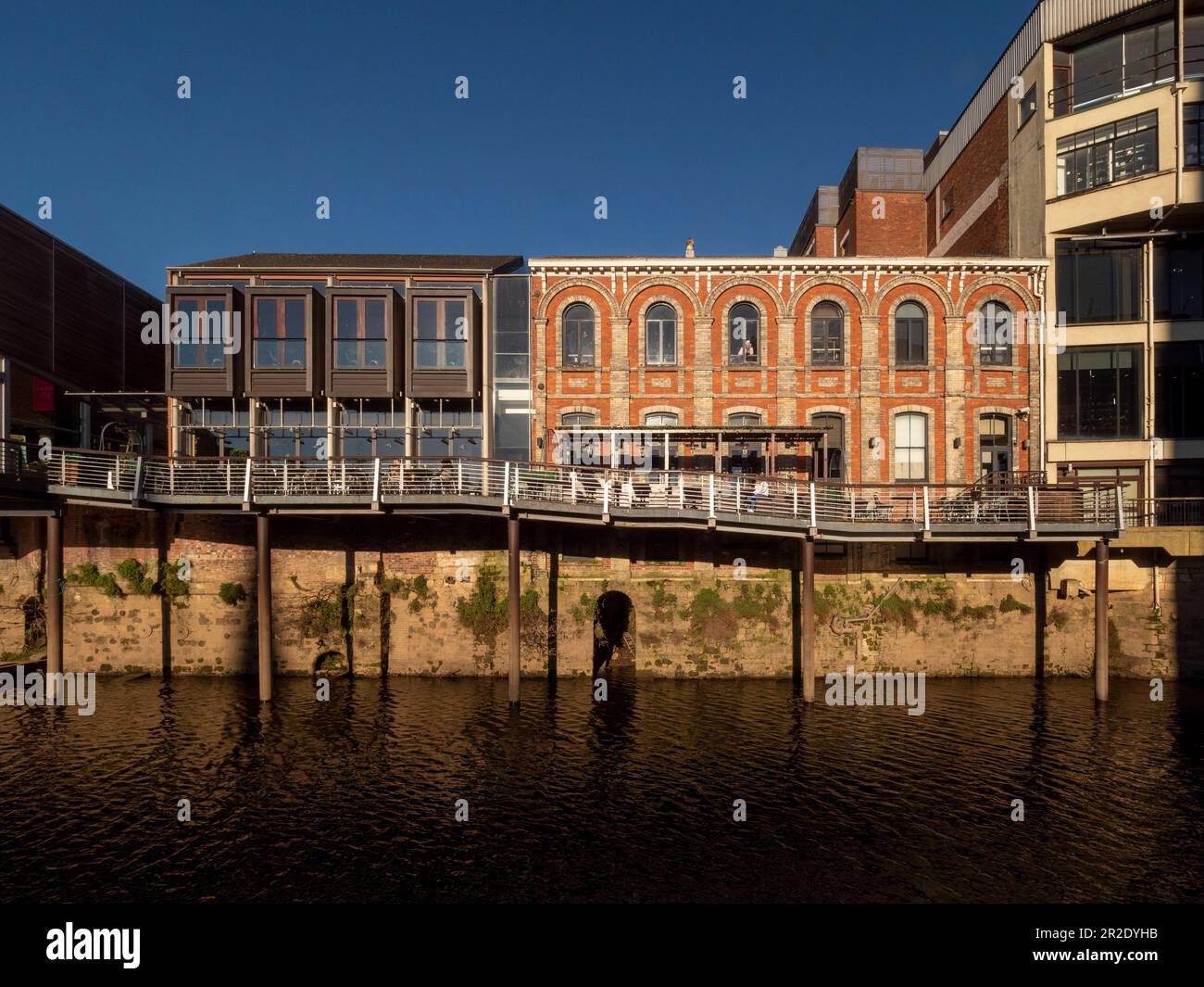Red brick facade of Ebor Hall, with modern side extension and terrace, now a restaurant overlooking the river Ouse in York.  North Yorkshire Stock Photo