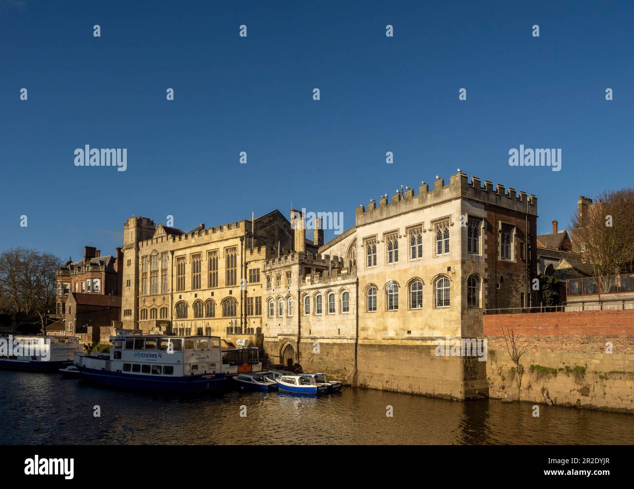 Moored tourist cruise boats on the river Ouse alongside the Guildhall. York. UK. Stock Photo