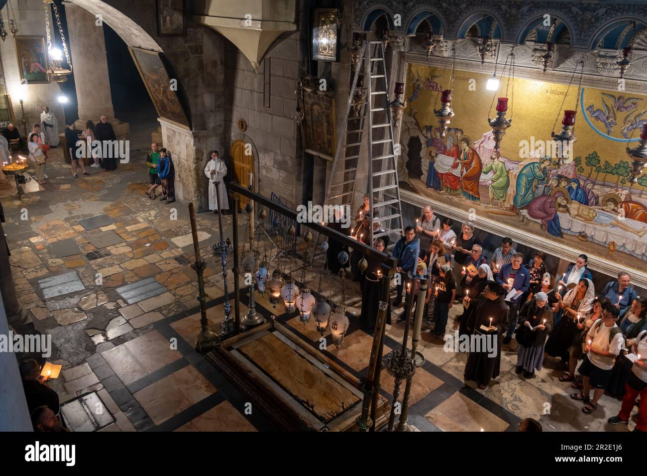 Jerusalem, Israel - 10 April, 2023. Priests, Tourists and pilgrims prayng at the Stone of Anointing in the church of holy sepulchre Stock Photo