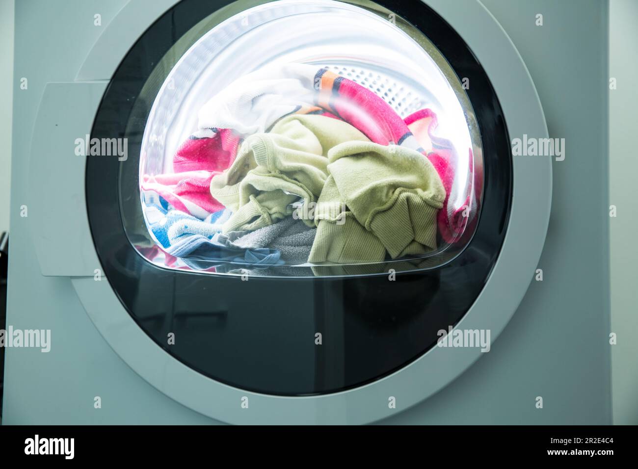 Dryer machine in a Landry room at home drying clothes. Spinning drum