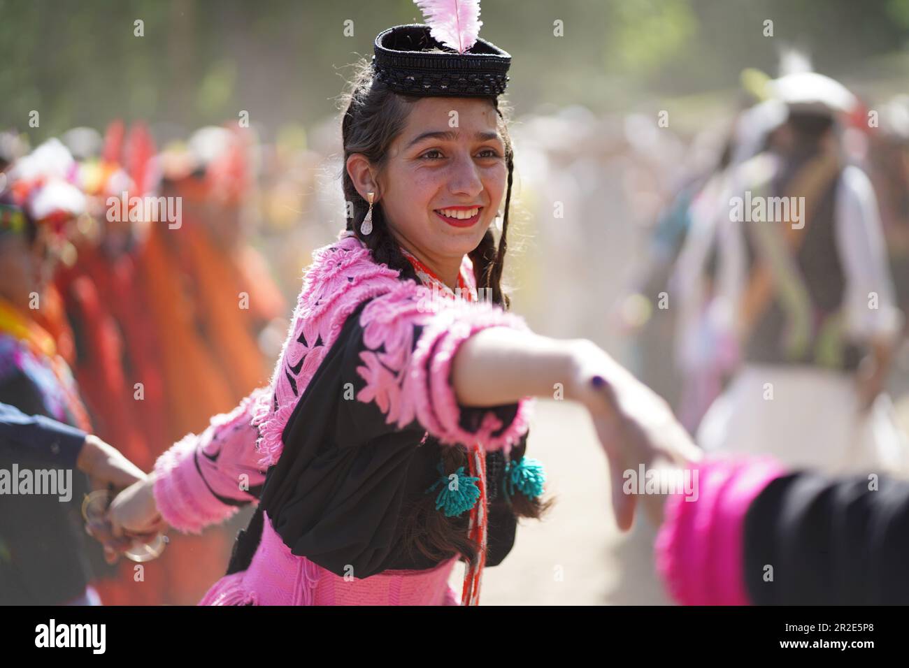Bamburet, KPK,Pakistan - 05152023: Kalash woman in a pink traditional dress dancing at the Chilam Joshi Festival in Chitral Stock Photo