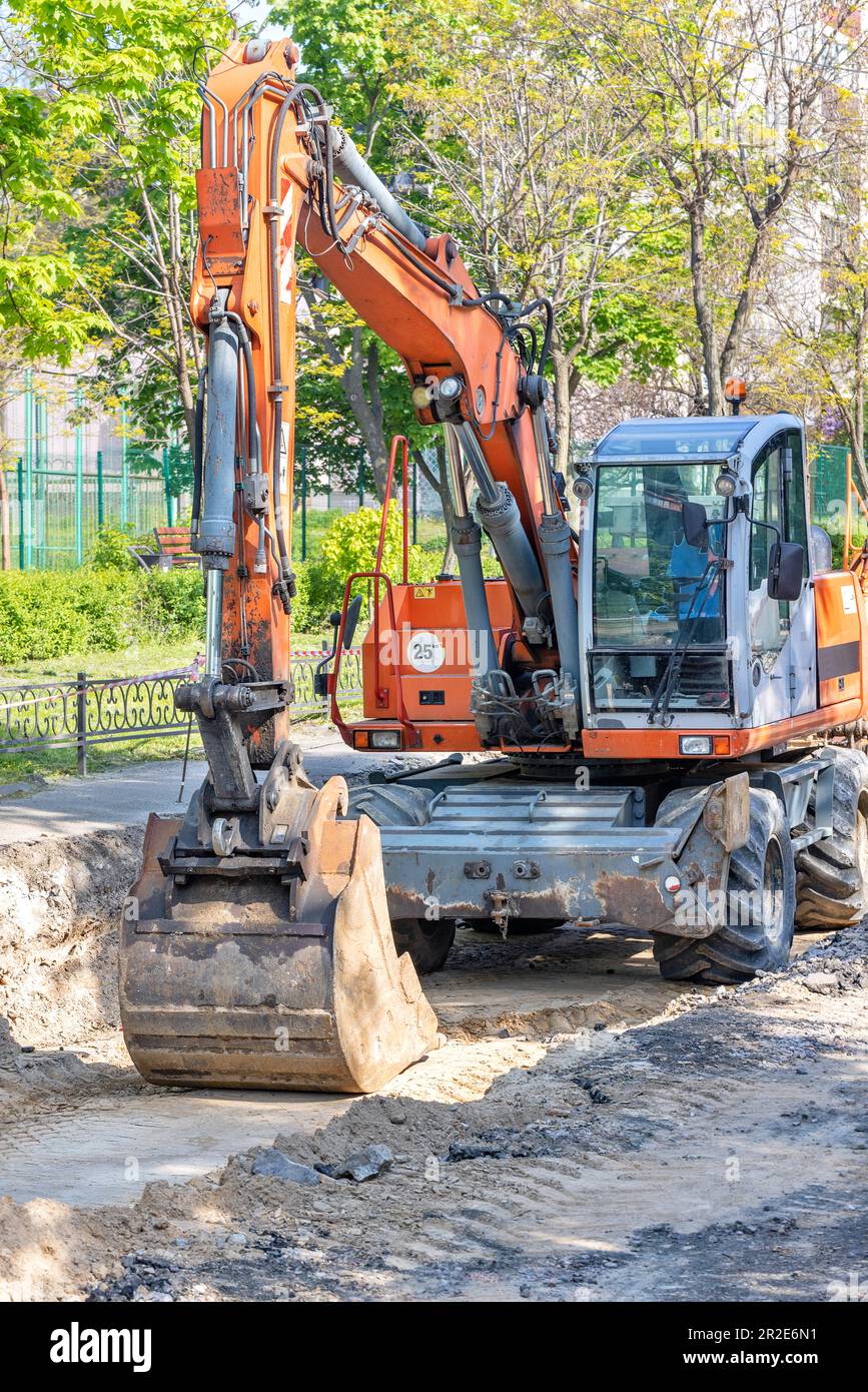 A large wheeled excavator is parked in a trench he dug in the middle of ...
