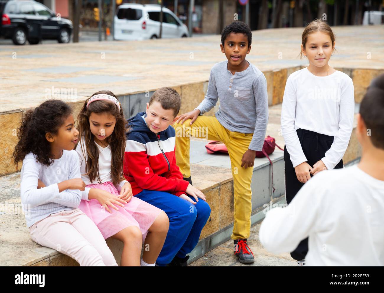 Children during conversation sitting on stairs outdoors Stock Photo