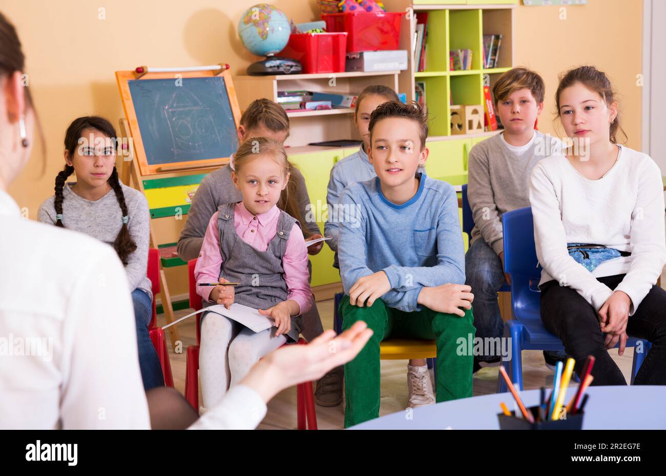 children sitting and listening teacher Stock Photo - Alamy