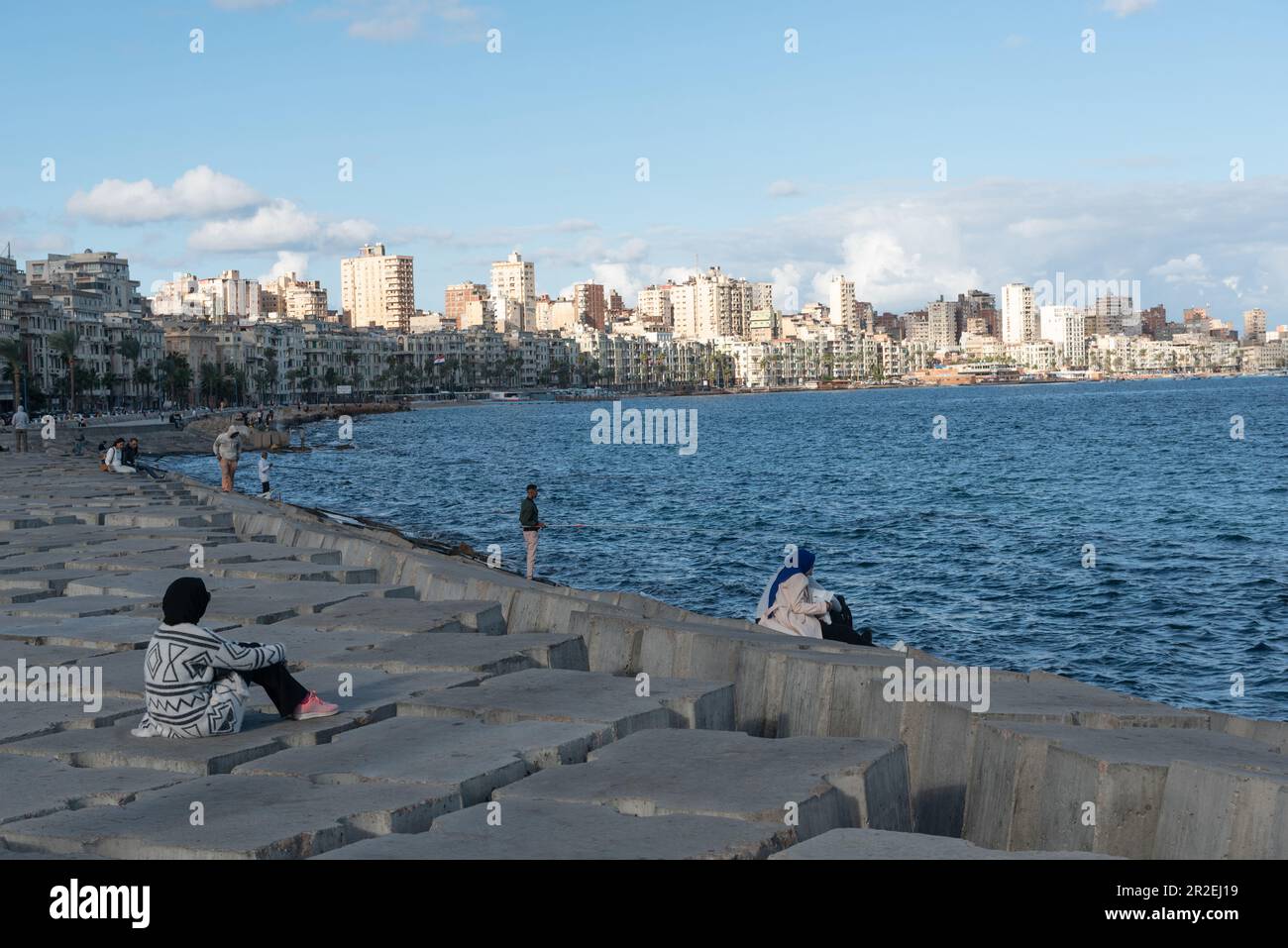 Alexandria, Egypt. 4th Dec, 2022. People sit on concrete blocks positioned as a defence against rising Mediterranean sea levels along the Corniche of Alexandria, the seconds largest city in Egypt. (Credit Image: © John Wreford/SOPA Images via ZUMA Press Wire) EDITORIAL USAGE ONLY! Not for Commercial USAGE! Stock Photo