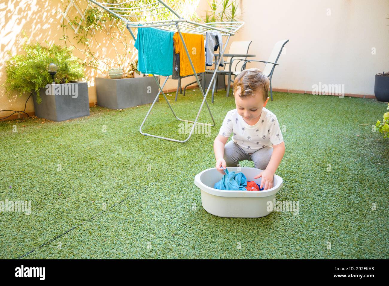 Funny boy with cloth and clothesline. Dry baby clothes on a rope Stock