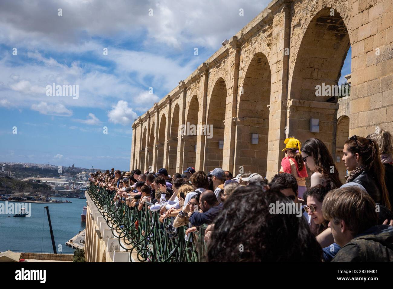 Valletta, Malta - April 18, 2023: Crowd of tourists on the balcony at Upper Barakka Gardens, watching Saluting Battery canon firing ceremony. Stock Photo