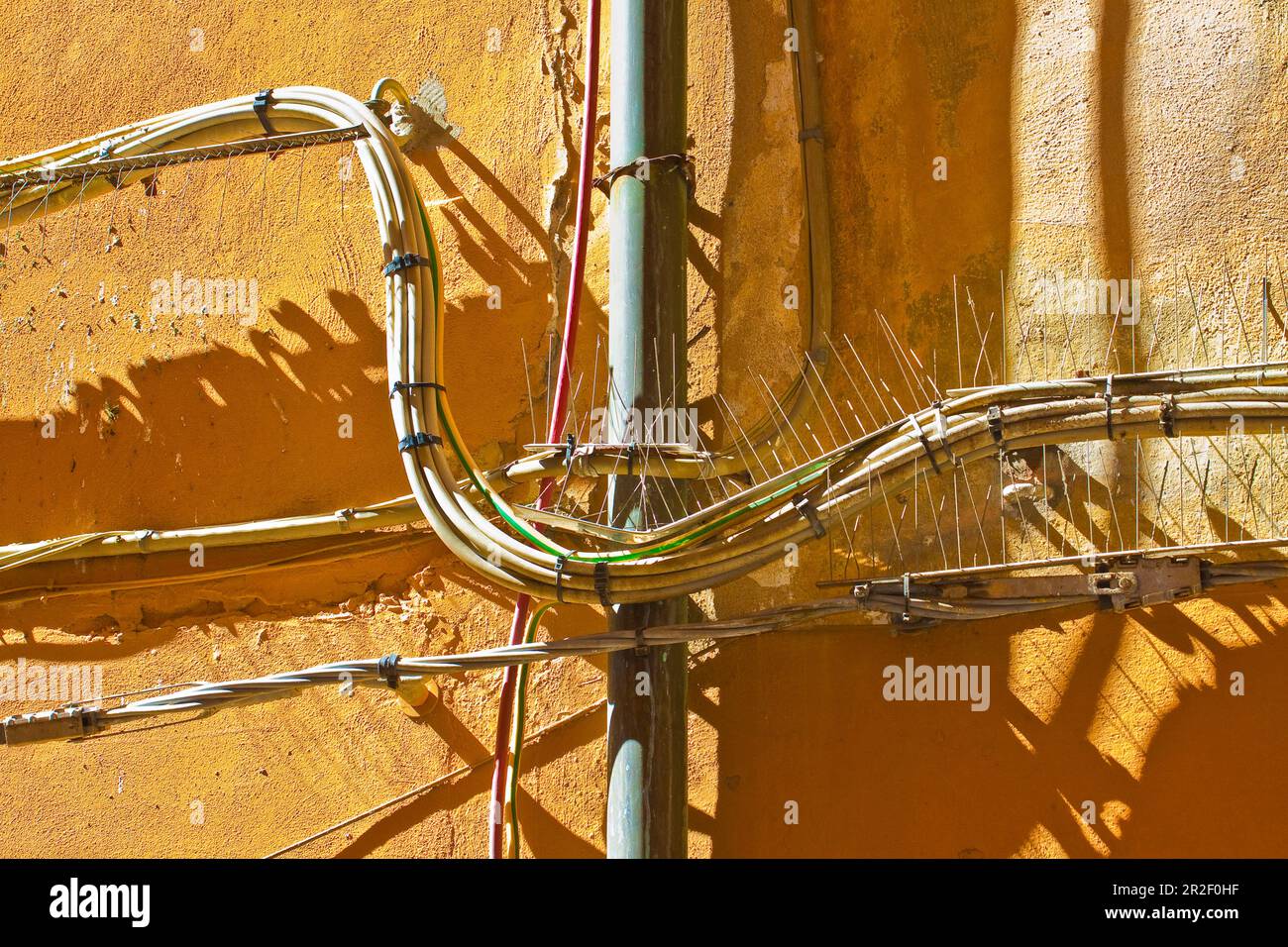 Electrical power cables and telephone cables against an old brick and