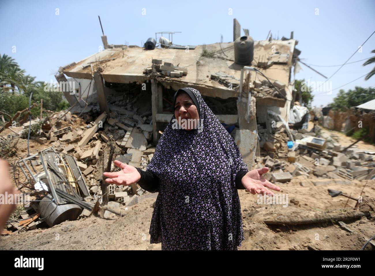 A woman is seen in front of a destroyed building belonging to the Al-Bashir Family after the Israeli attacks in Deir Balah, Gaza City. Palestine. Stock Photo