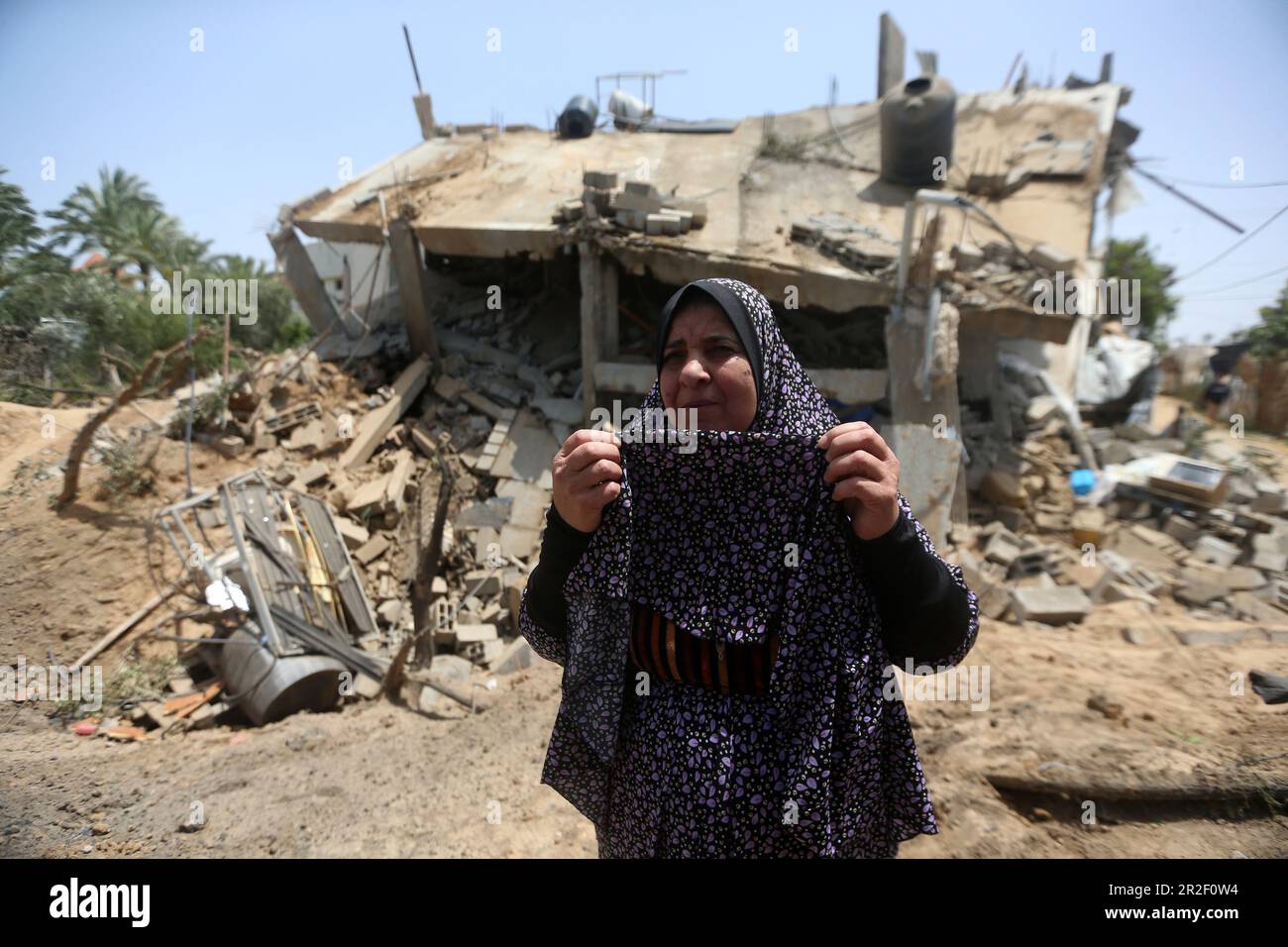 A woman is seen in front of a destroyed building belonging to the Al-Bashir Family after the Israeli attacks in Deir Balah, Gaza City. Palestine. Stock Photo