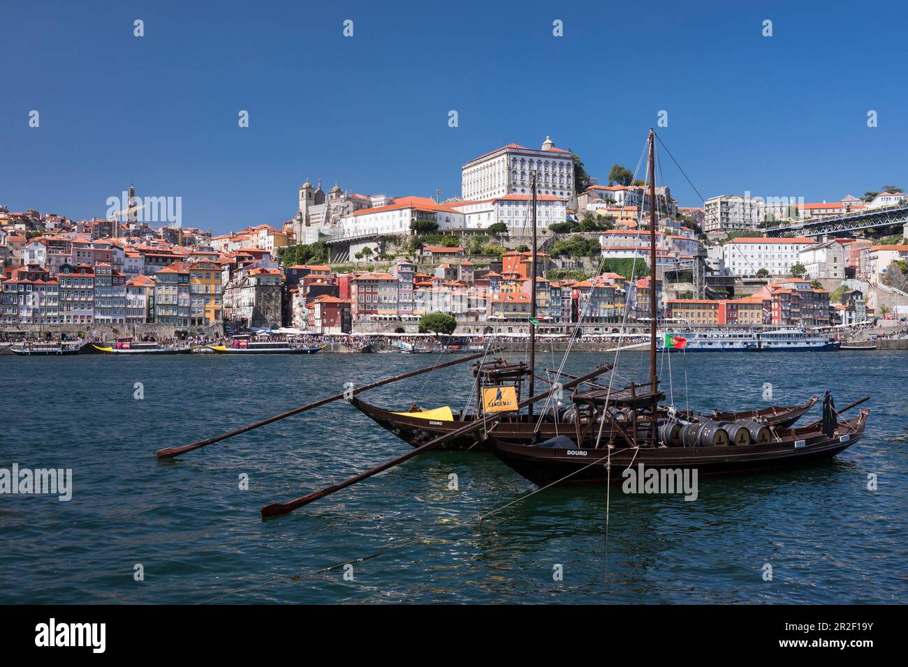 Traditional ships on the Douro river in Porto by day with sun, Portugal