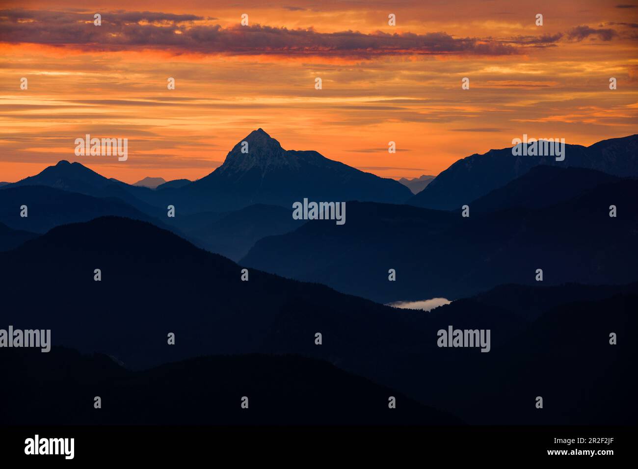 Mountain silhouettes of the Bavarian Prealps on Lake Walchensee in sunrise, from Jochberg Stock Photo