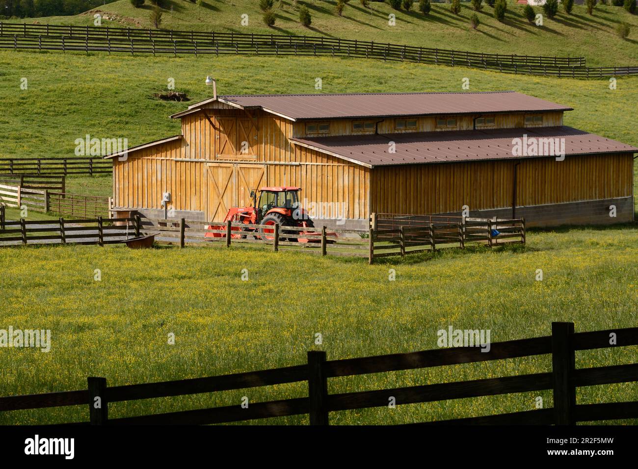 A Kubota tractor parked beside a cattle barn on a farm in Abingdon