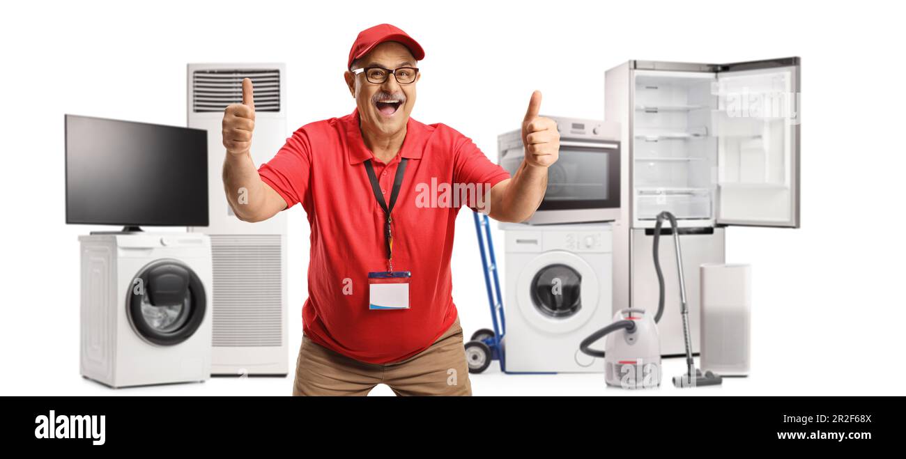 Excited mature salesman gesturing thumbs up in front of electrical appliances isolated on white background Stock Photo