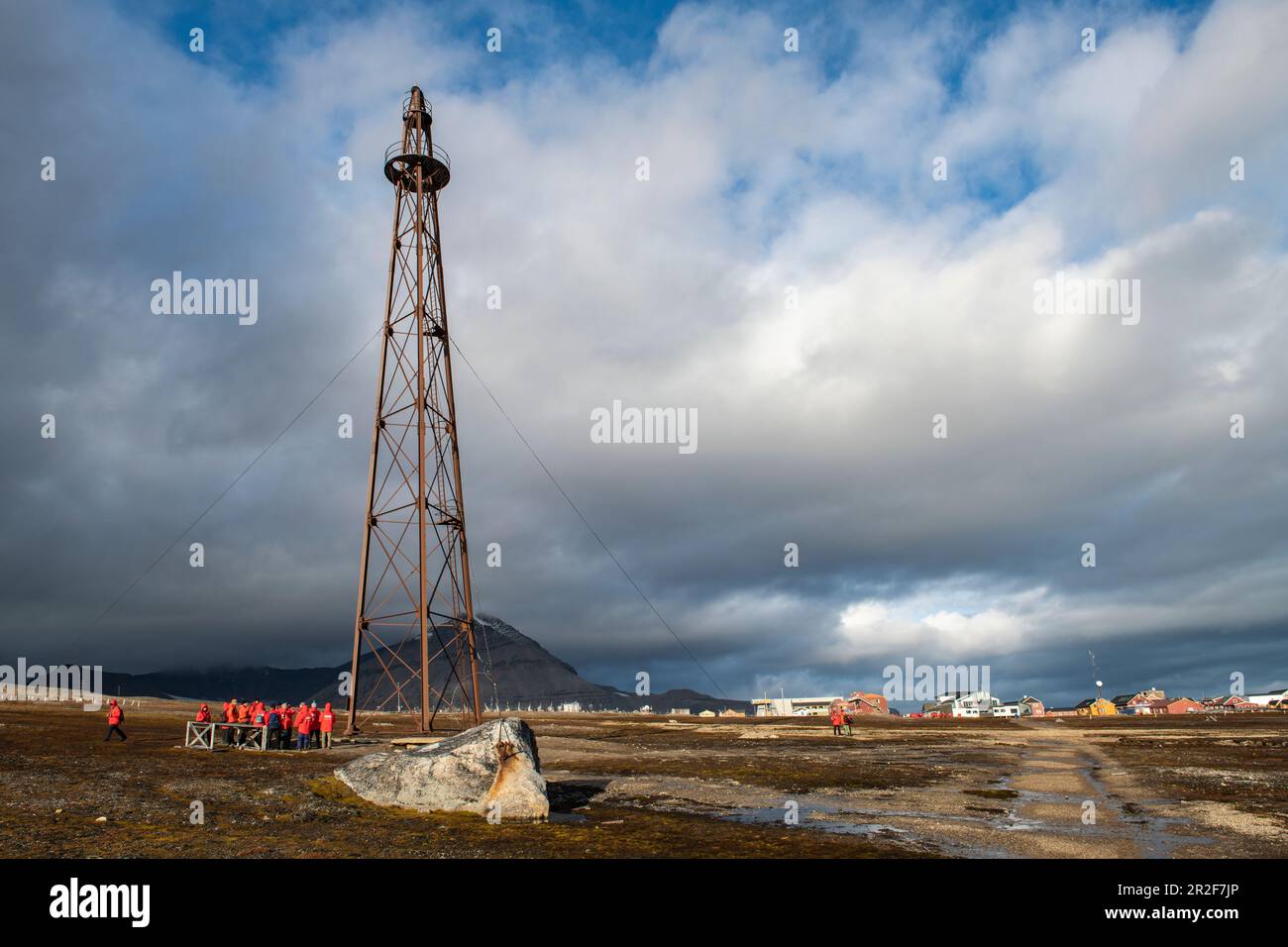 Expedition cruise ship passengers gather at the foot of the tower from