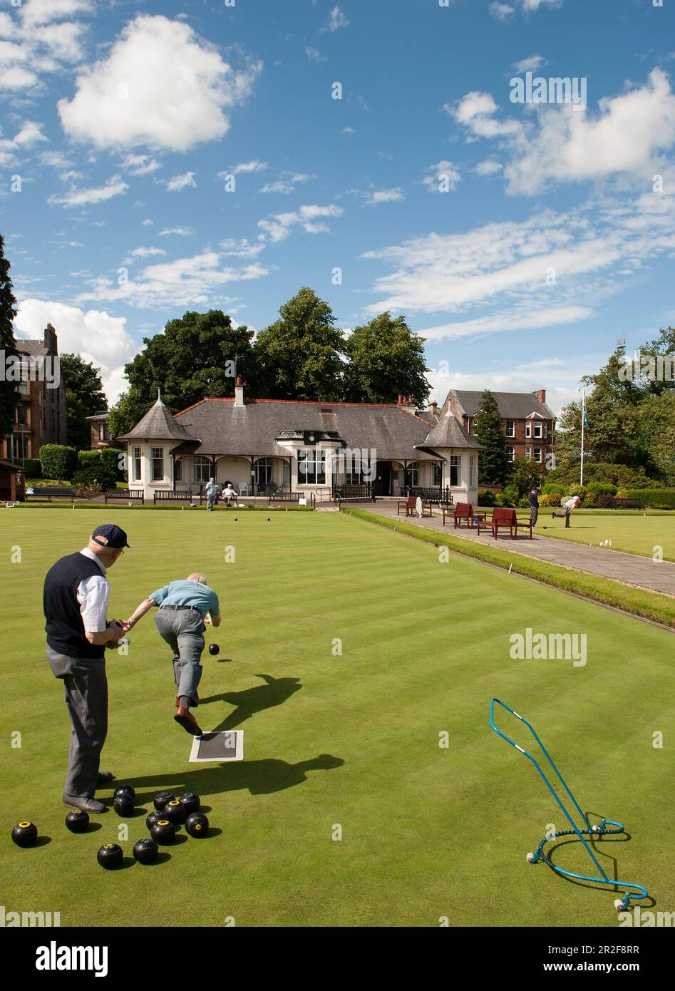 Men bowling in front of the pavilion of the Ardgowan lawn bowling Green in Greenock, Scotland Stock Photo