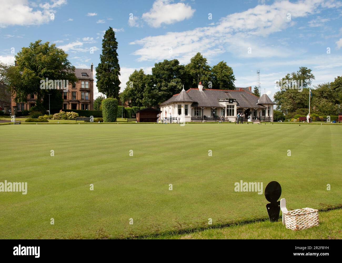 Men bowling in front of the pavilion of the Ardgowan lawn bowling Green in Greenock, Scotland Stock Photo