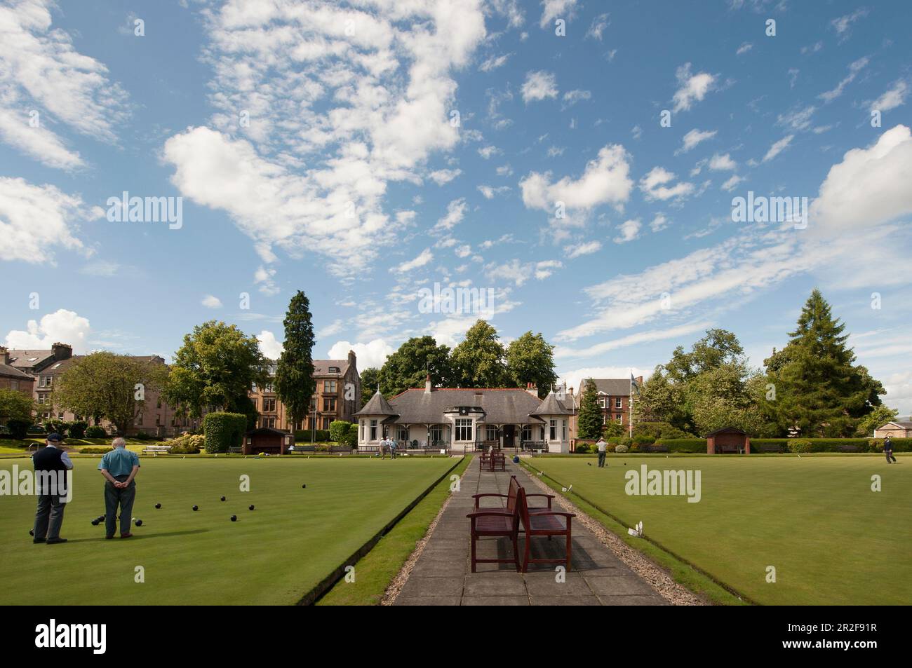 Men bowling infront of the pavilion of the Ardgowan lawn bowling Green in Greenock, Scotland Stock Photo