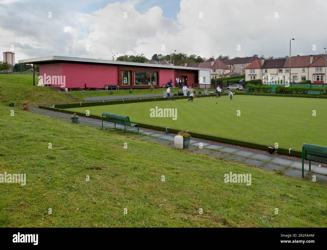 Bowls in play in front of the red pavilion clubhouse at the Balornock lawn bowling green in Glasgow, Scotland, UK Stock Photo