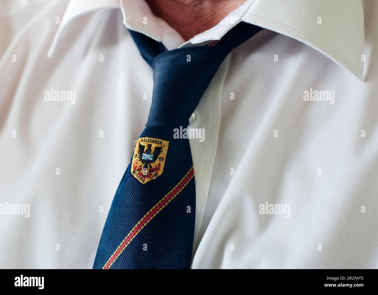 A man wears a white shirt and tie with the club emblam for the Balornock lawn bowls club in Glasgow, Scotland Stock Photo