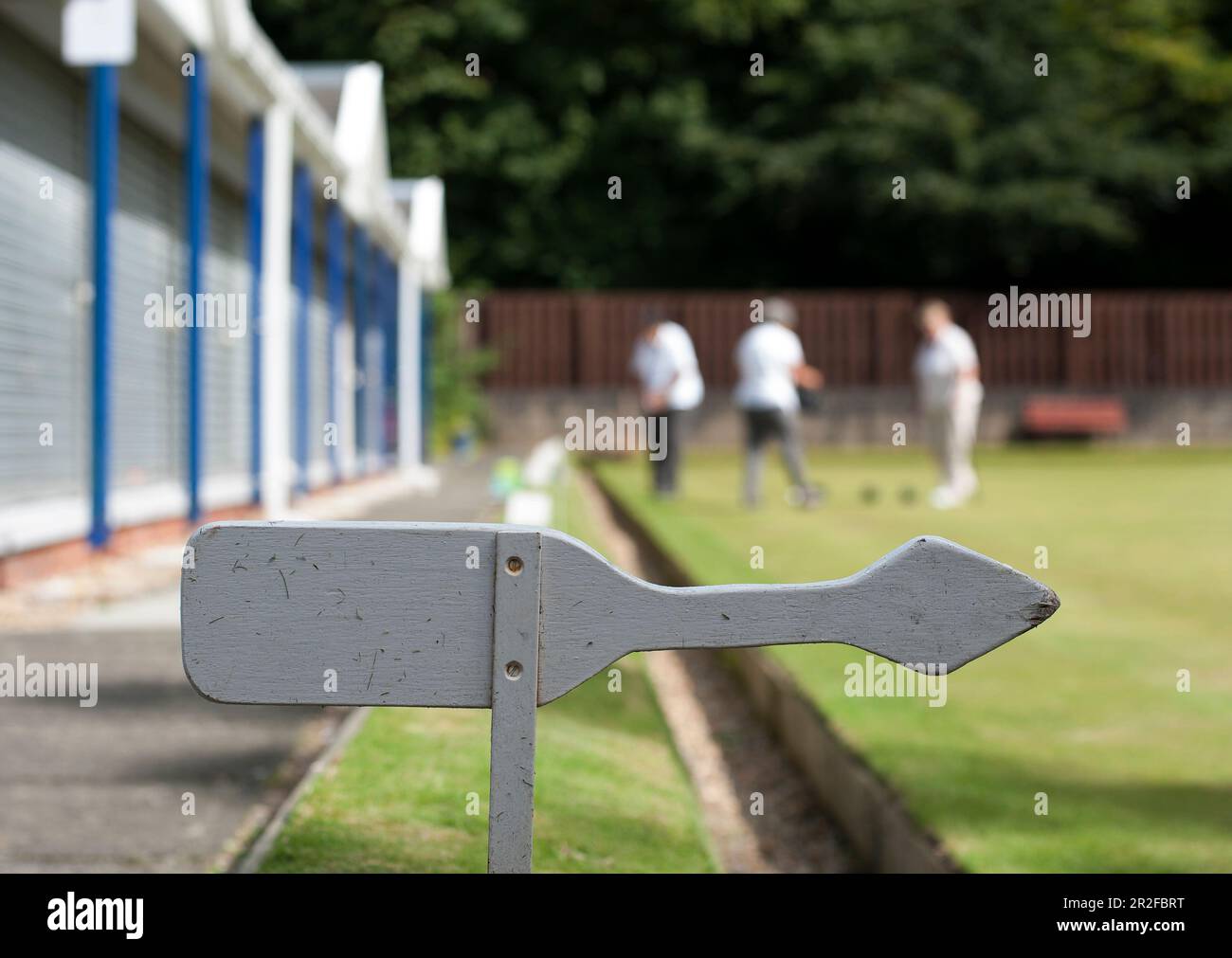An arrow sign in front of bowls in play at the Kilmarnock lawn bowling green in Kilmarnock, Ayrshire, Scotland, UK Stock Photo