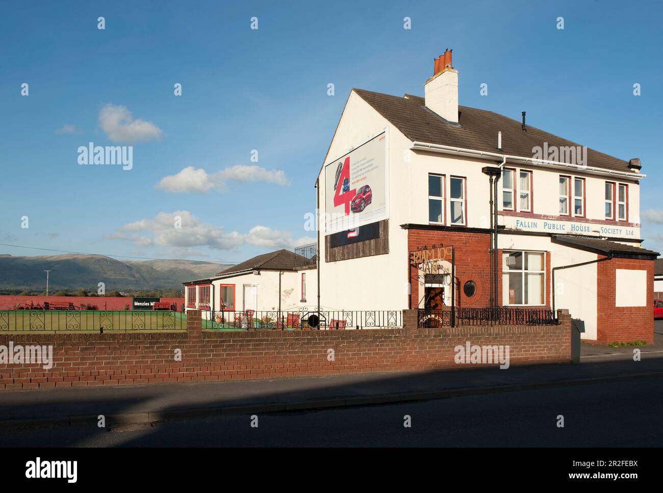 Fallin Public House Society Limited building with a large advertising sign beside the Polmaise lawn bowling club green beneath the Ochil hills in Fall Stock Photo