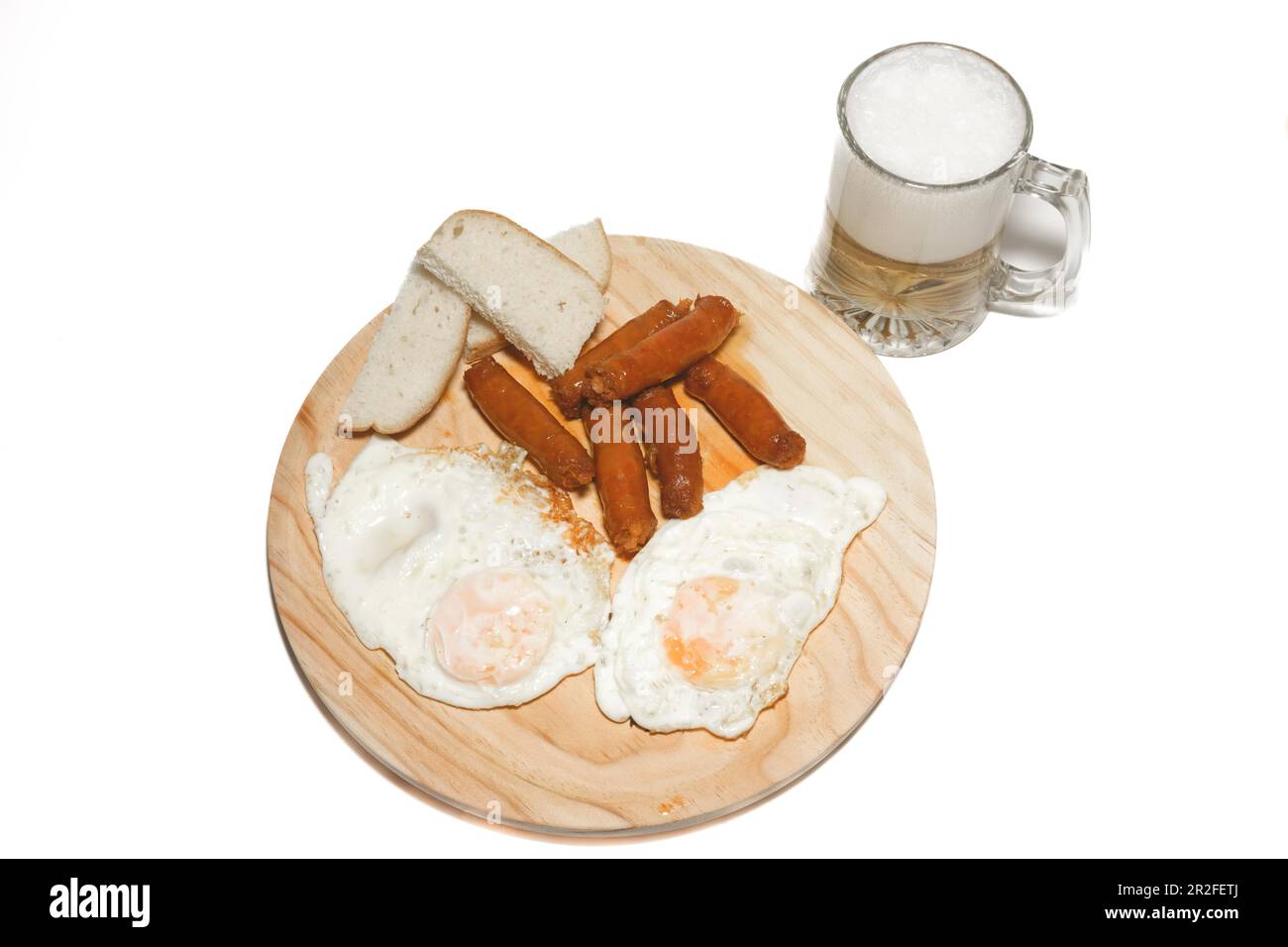 Typical spanish meal of fried eggs with sausage, bread and mug of beer isolated on white background and copy space Stock Photo