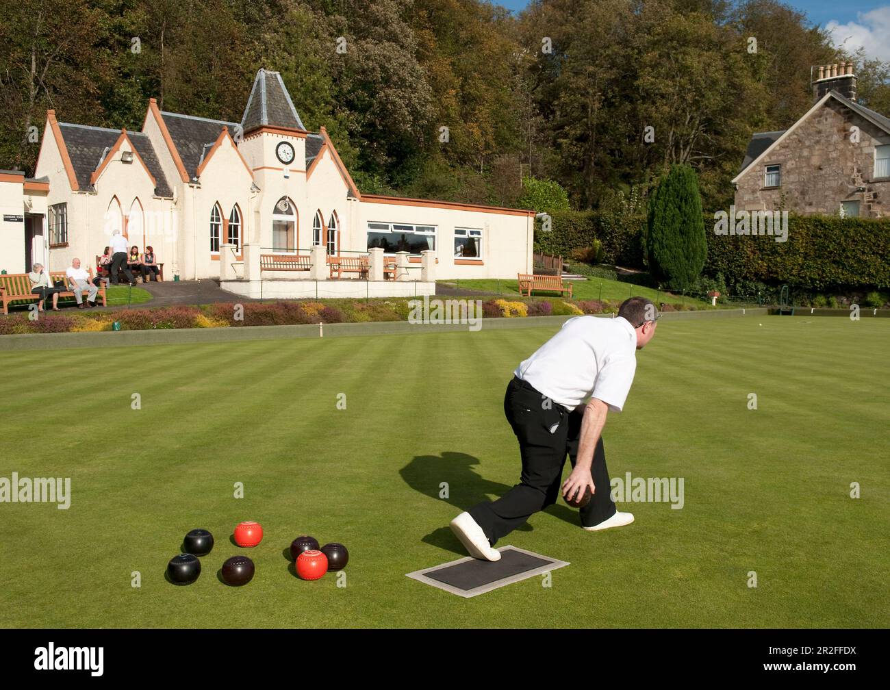 Bowls in play in front of the pavilion of the Stirling lawn bowling club green in Stirling, Scotland, UK Stock Photo