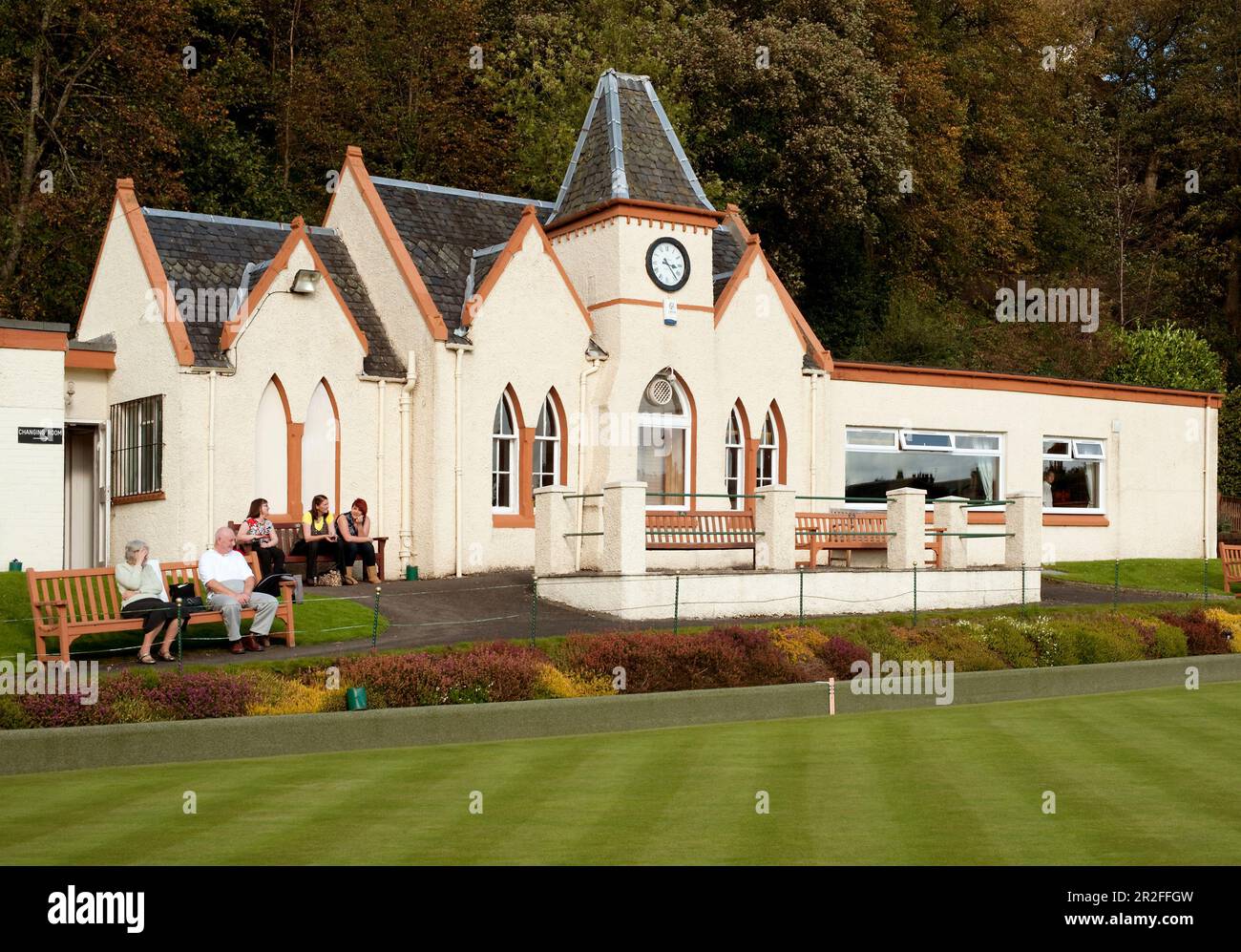 A crowd sit and watch bowls in play in front of the pavilion of the Stirling lawn bowling club green in Stirling, Scotland, UK Stock Photo