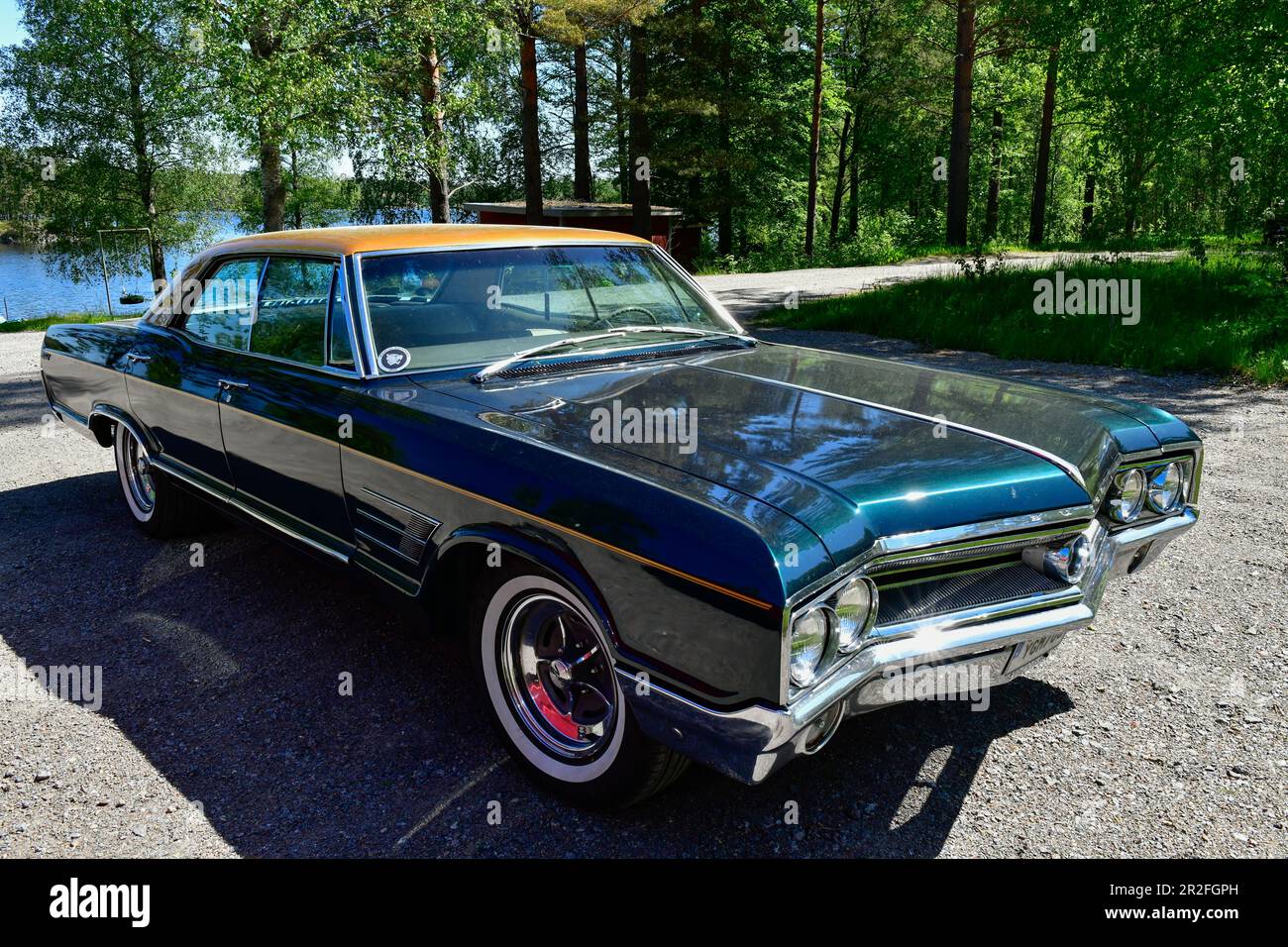 An old Buick stands by a lake and shines in the sun, Örebro Province, Sweden Stock Photo
