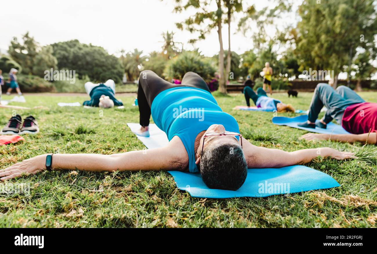 Close up senior woman doing workout activity with a group of friends in a public park - Health elderly people lifestyle Stock Photo