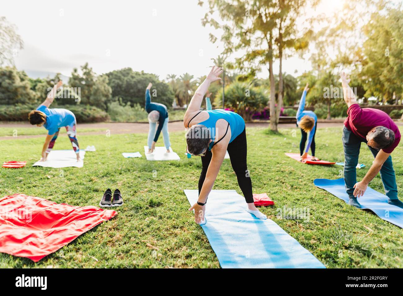 Happy senior friends doing workout activity in a public park - Health elderly people lifestyle Stock Photo