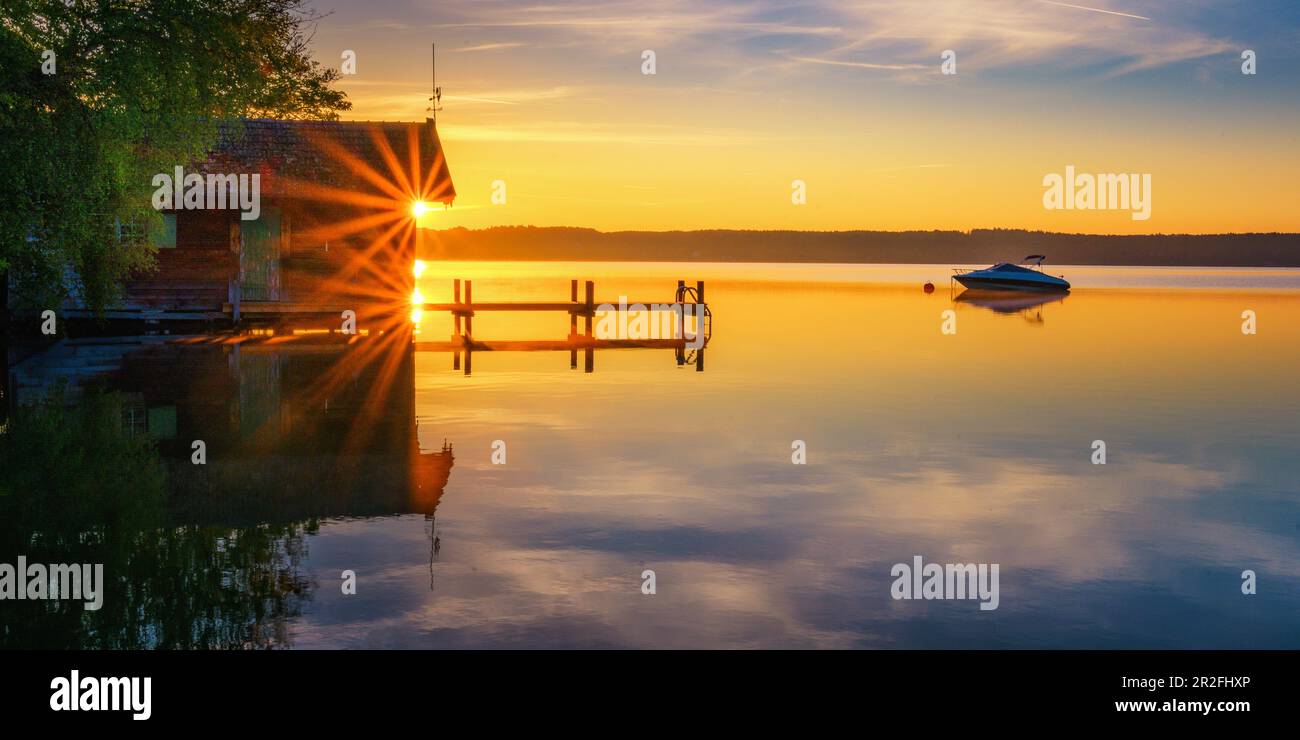 Boothaus silhouette with jetty at sunrise on Lake Starnberg, Bavaria, Germany Stock Photo