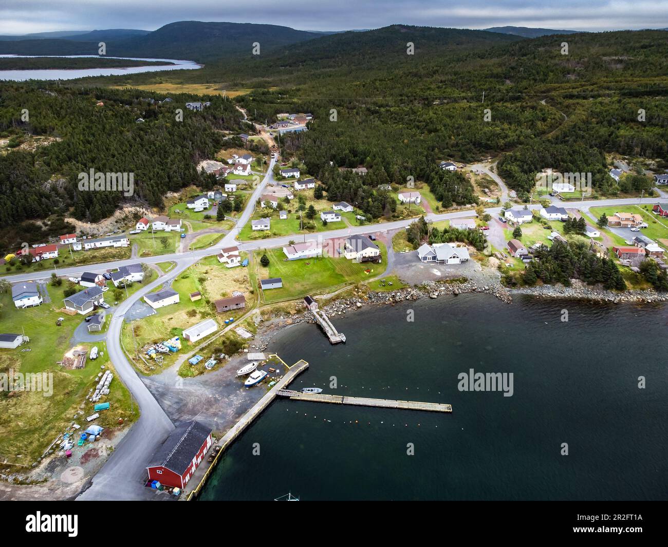 Aerial small East Coast village of Whiteway Newfoundland overlooking boat docks and breakwater with vacation homes overlooking the Atlantic Ocean. Stock Photo