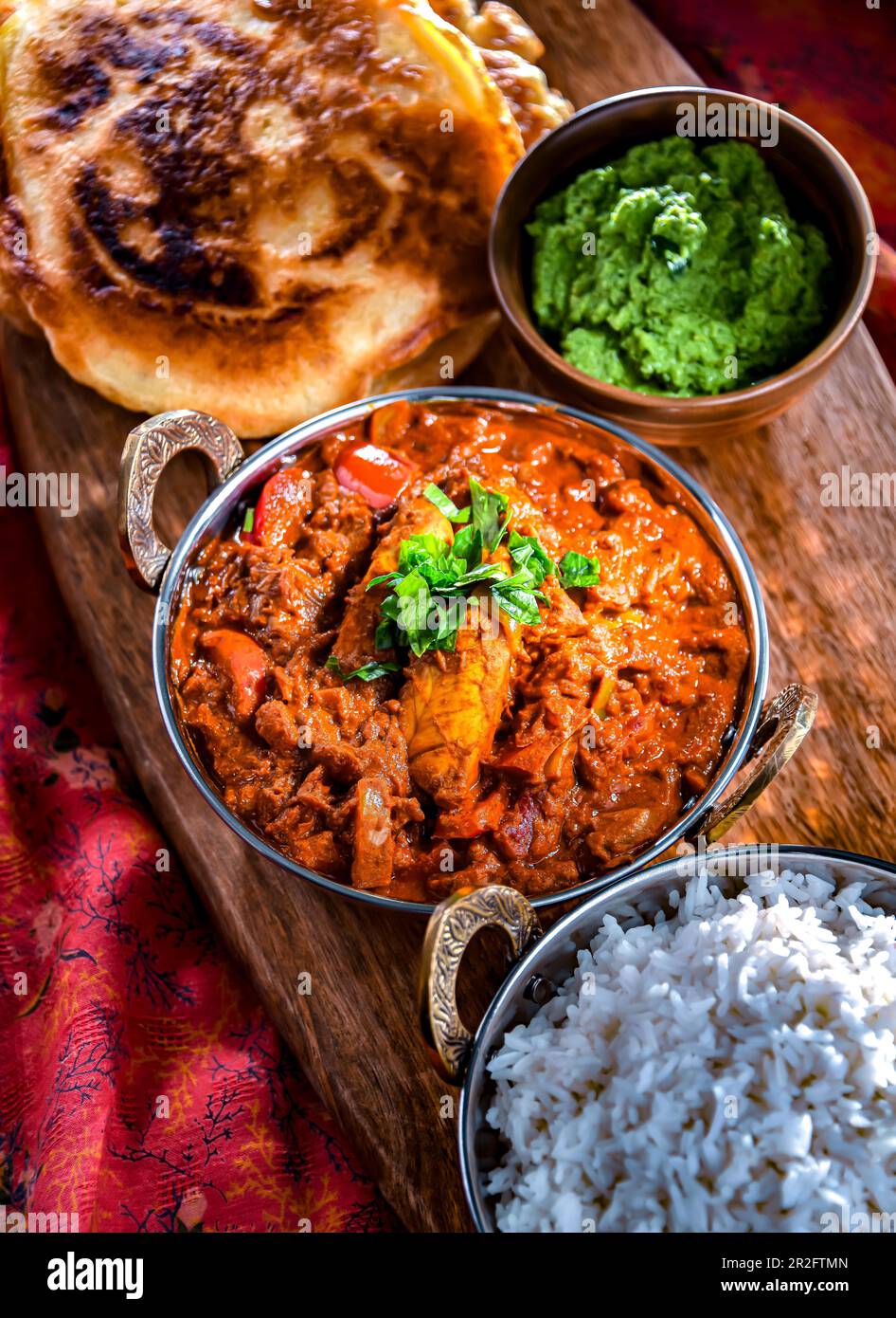 Butter chicken with rice and naan flatbread served in original indian karahi pots Stock Photo