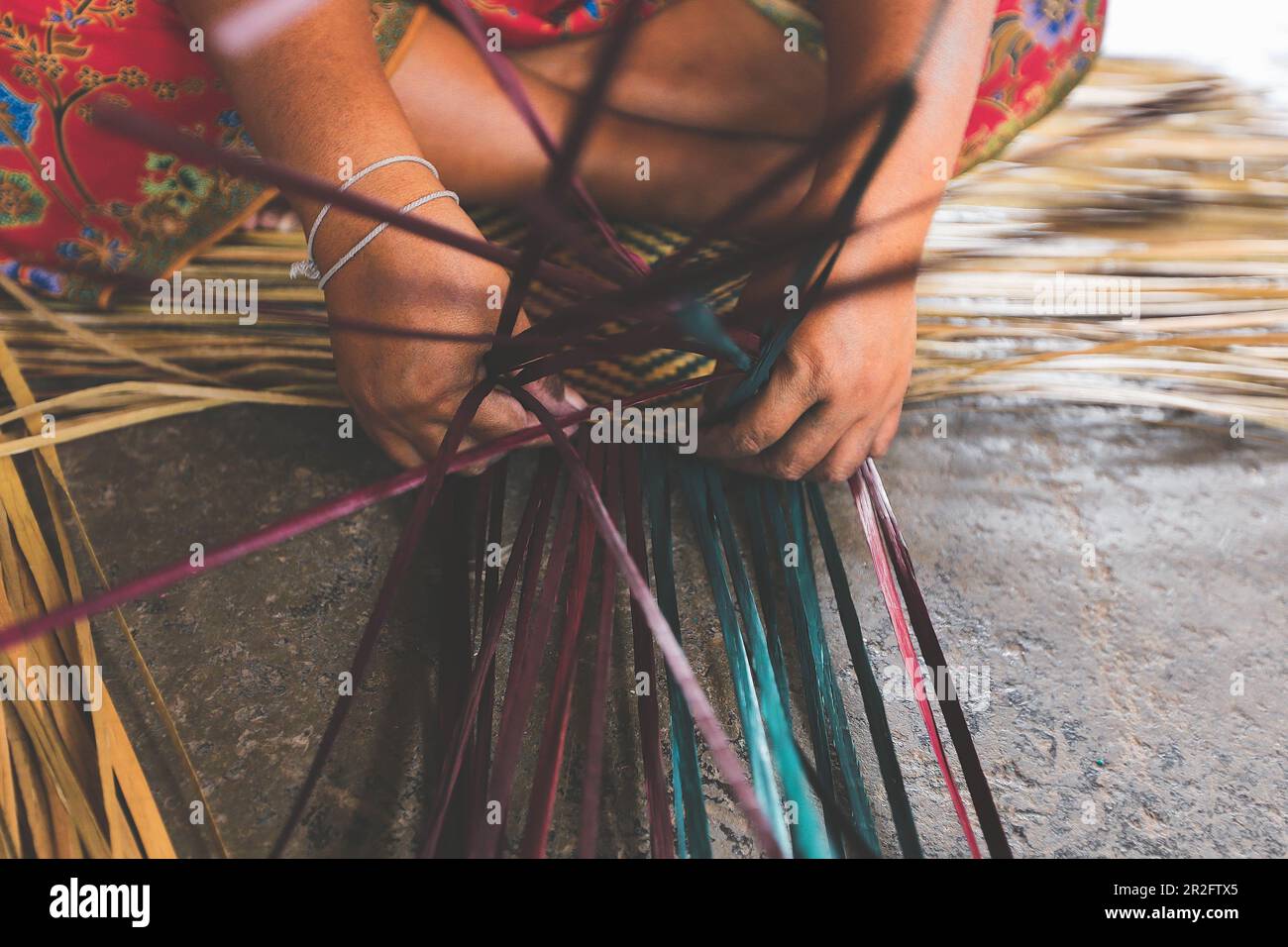 Selective focus on woman's hands weaving a krajood mat, Natural products from Taley Noi, Pattalung, Thailand Stock Photo