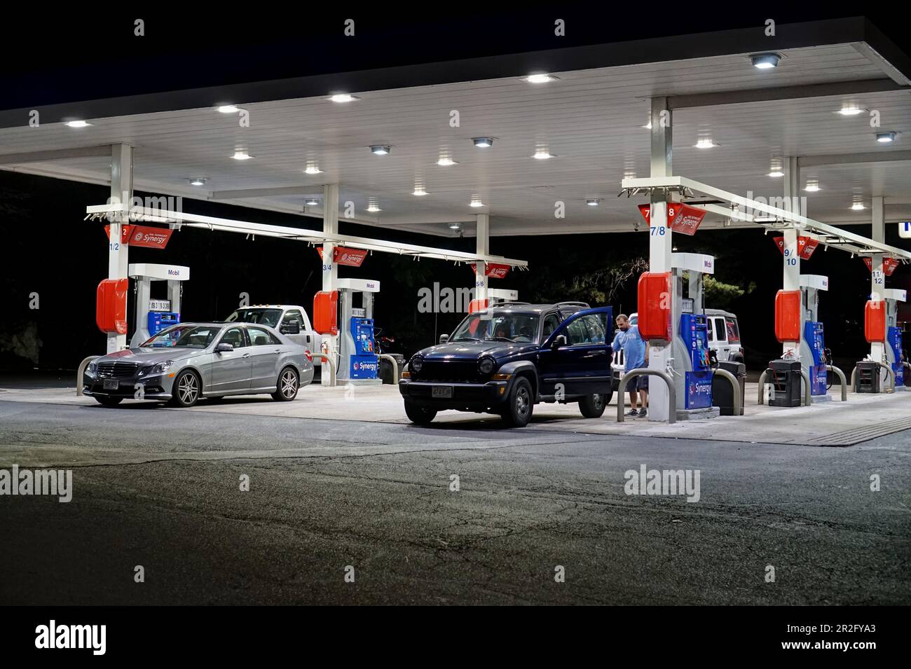 Mobil gas station fuel pumps fill up, night USA Stock Photo