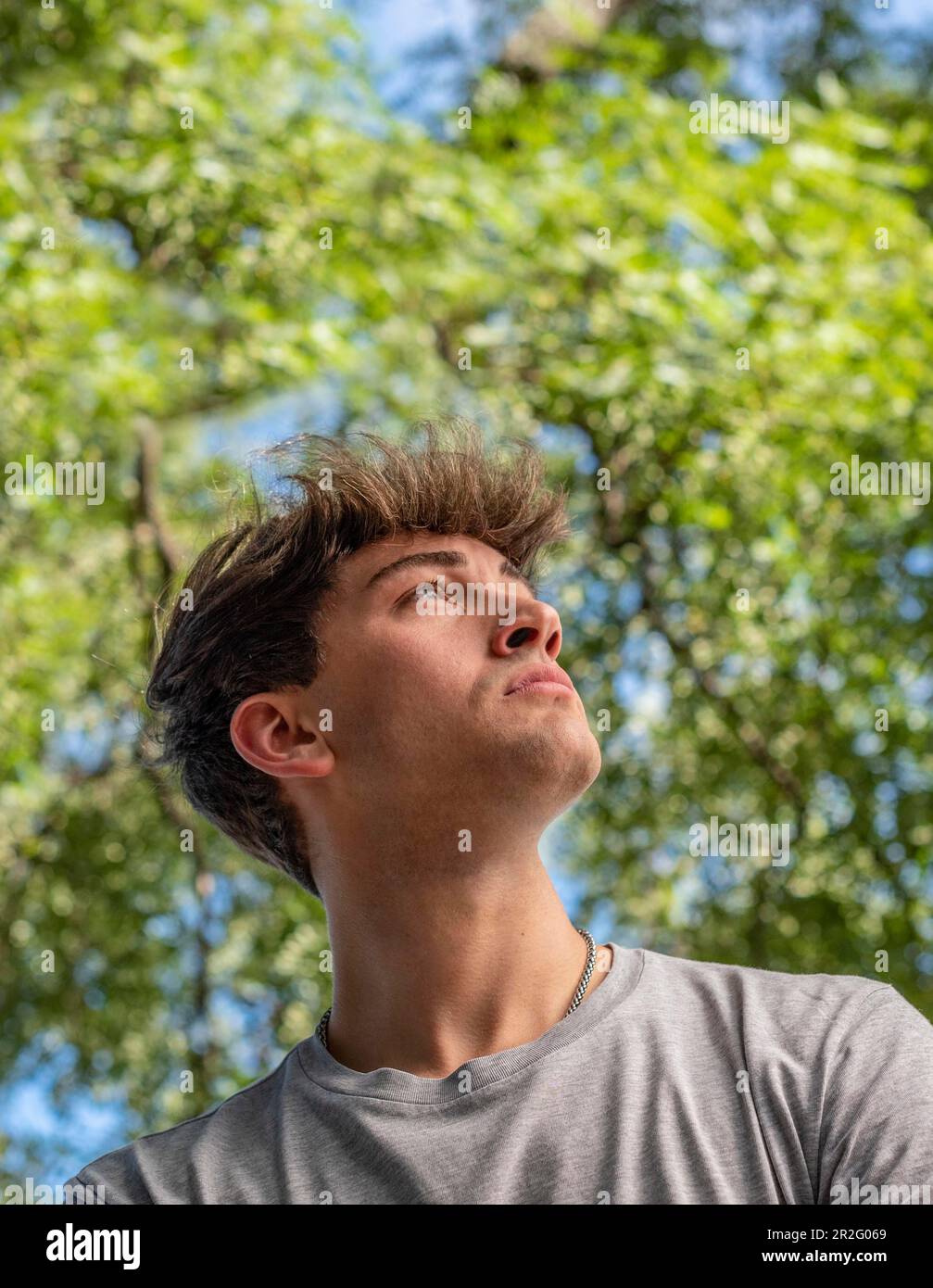 Side view of a young man who is looking up over nature background Stock Photo