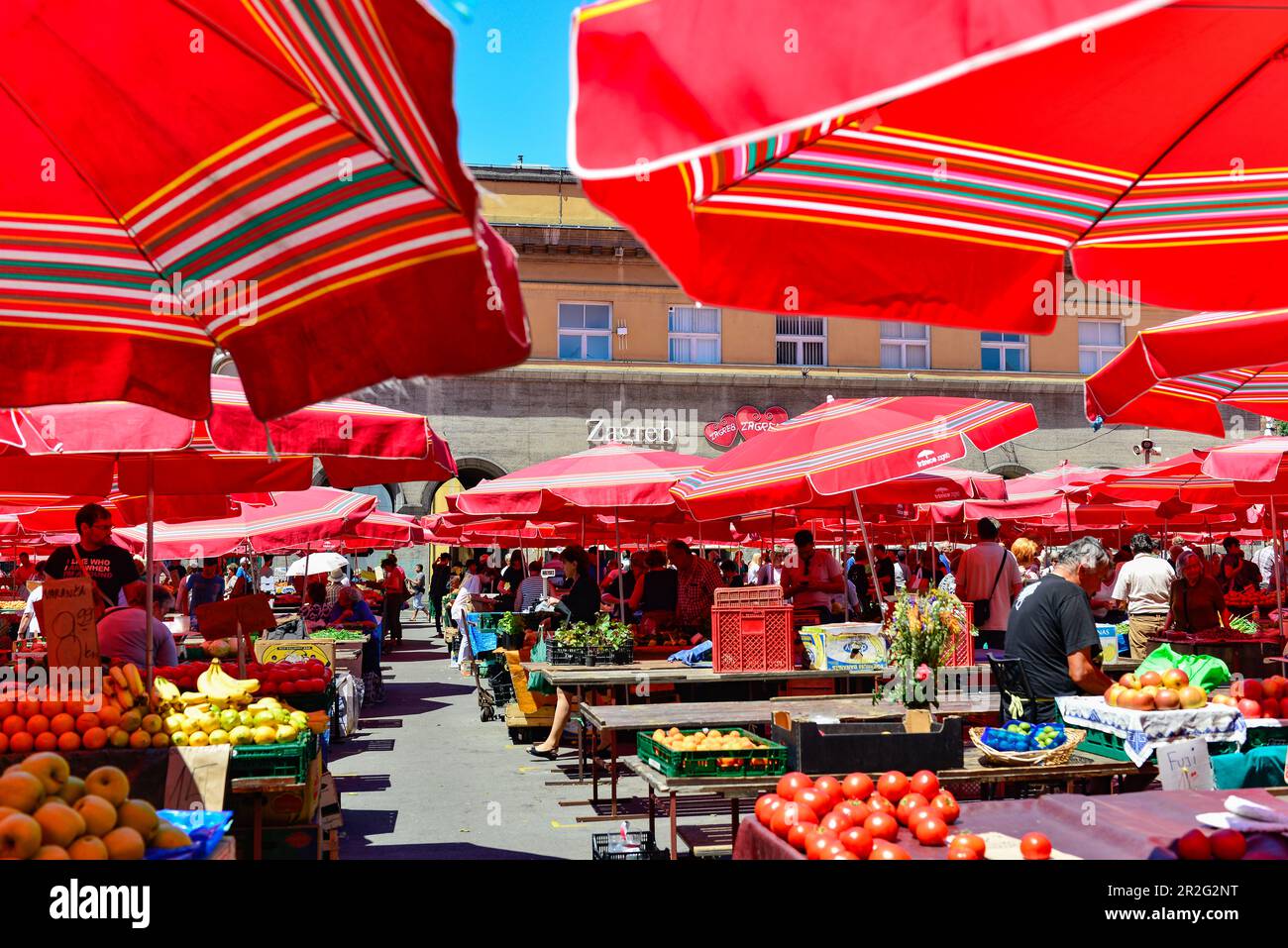 The busy fruit market with red parasols in Zagreb, Croatia Stock Photo