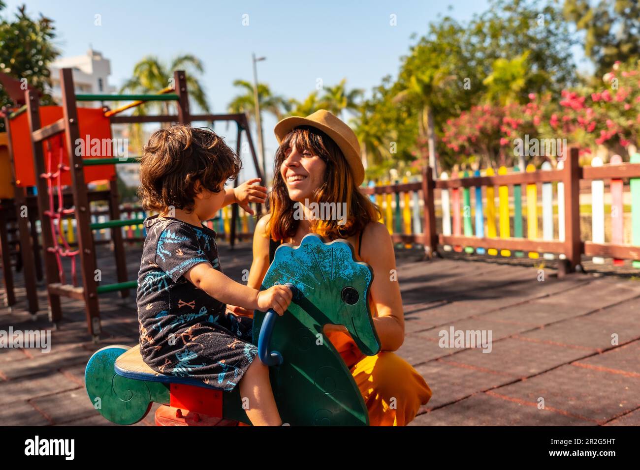 Mother playing with her son in a playground on summer vacation Stock Photo