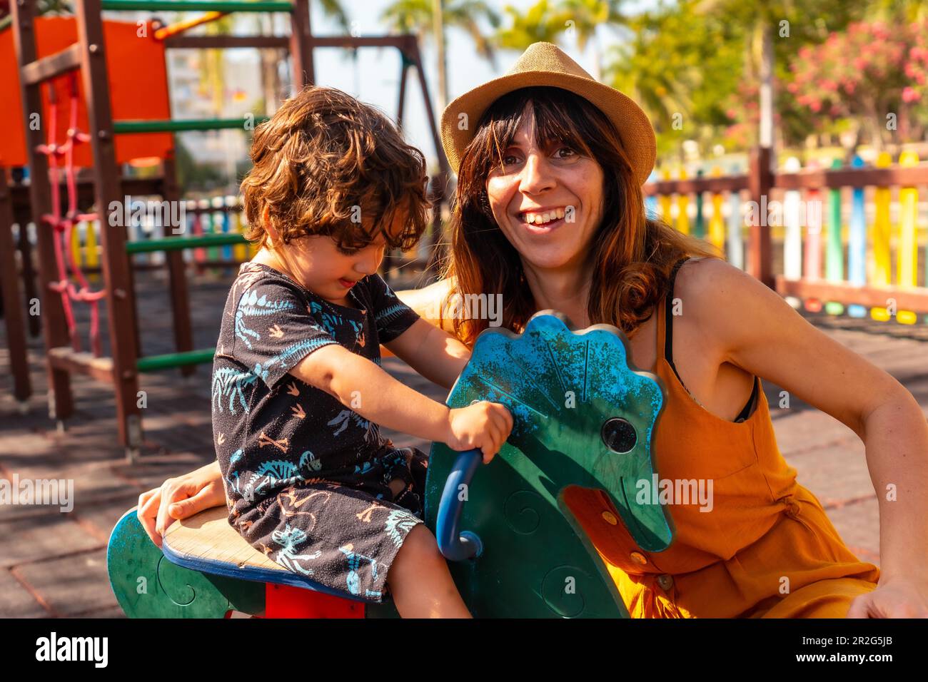 Mother playing with her son in a playground on summer vacation Stock Photo