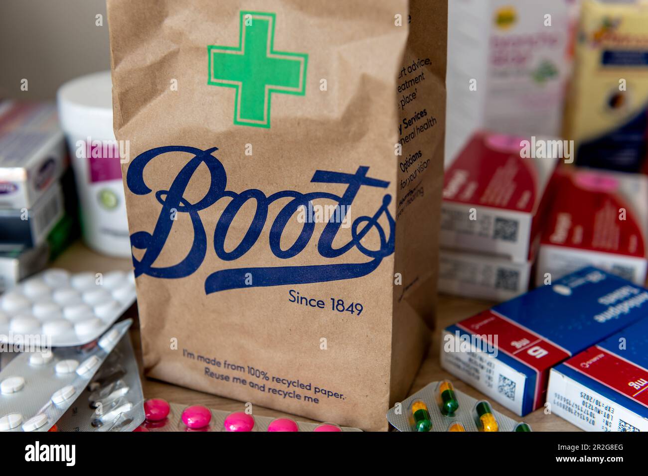 London. UK- 05.14.2023. A brown paper bag from the pharmacy and beauty retailer Boots with the company name and pharmacy symbol printed in front. Stock Photo