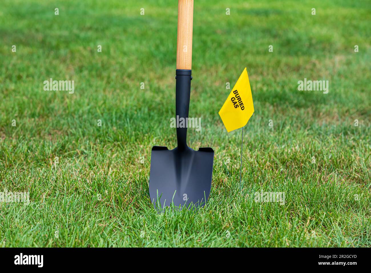 Natural gas utility warning flag with shovel. Notify utility locate company for underground utilities, call before you dig and digging safety concept Stock Photo
