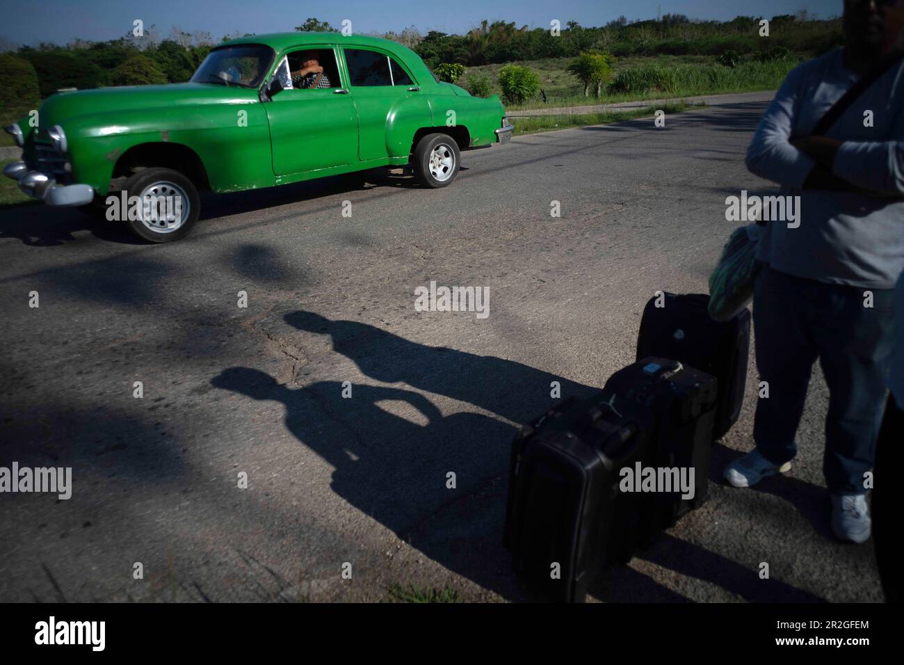 People with suitcases wait for an available bus or a taxi on the